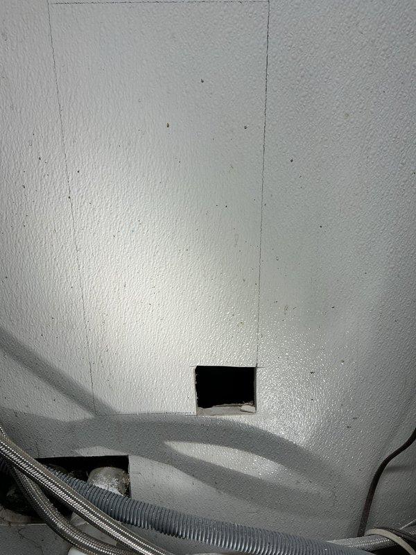 Diagnosed and resolved clogged bathroom sink drain line connected to laundry tub sink. Identified blockage in galvanized pipe within wall, cut access panel, and performed line cleaning to restore proper drainage function.