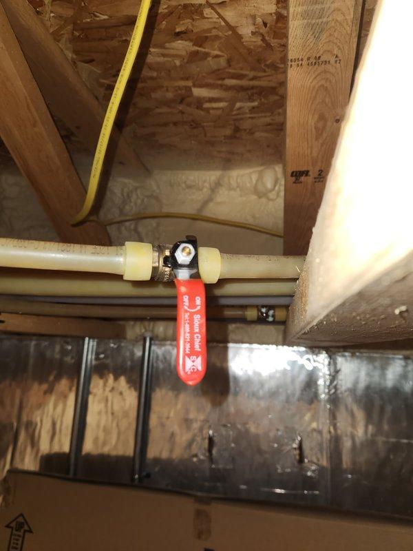 Replaced two corroded brass ball valves exhibiting pinhole leaks in the plumbing system. Leakage likely caused by high pH levels in water or excessive water velocity through PEX piping from recirculation pump. New valves installed within wooden framed structure with proper connections to existing PVC piping.