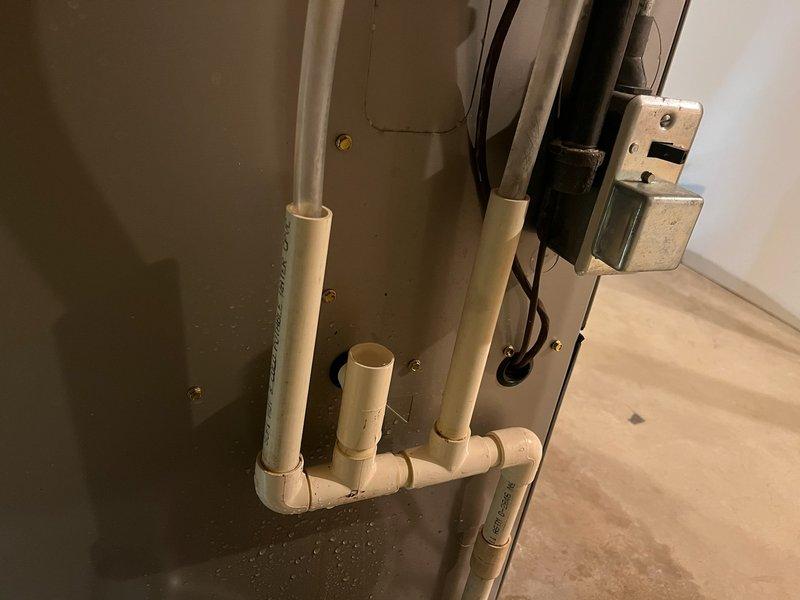 Responded to service call for water accumulation around furnace. Diagnosed completely plugged condensate line causing drainage issues. Installed new condensate drain line from furnace to proper drain point to restore proper drainage function. Provided customer with estimate for potential interior furnace trap replacement if moisture issues persist.