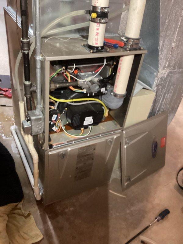 Responded to service call for water accumulation around furnace. Diagnosed completely plugged condensate line causing drainage issues. Installed new condensate drain line from furnace to proper drain point to restore proper drainage function. Provided customer with estimate for potential interior furnace trap replacement if moisture issues persist.