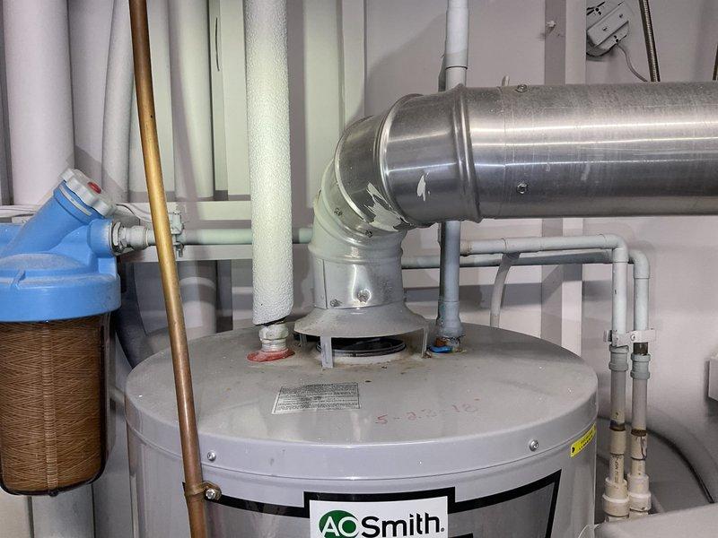 Responded to service call for leaking 7-year-old AO Smith 40-gallon natural gas water heater. Upon inspection, determined unit was not repairable and installed new 40-gallon natural gas atmospheric vented water heater with proper connections to existing gas line, water lines, and ventilation system.