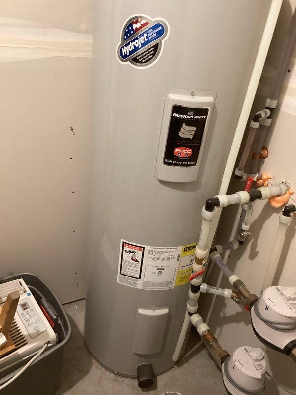 Diagnosed and resolved no-heat condition on Goodman furnace displaying lockout code due to excessive retries. Found water trapped in pressure switch hose due to improper routing, causing switch failure. Corrected hose routing to eliminate water trap and verified proper operation for 20 minutes with no fault codes. Noted presence of recall blower pressure switch update kit board already installed on unit.