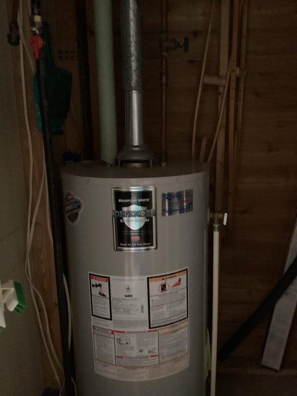 Responded to service call for tank water heater producing only warm water. Diagnosed pilot light was out. Performed inspection of pilot assembly and burner system. Successfully relit pilot light, restoring proper heating function. Noted 5-inch flue pipe connected to 3-inch water heater connection and possible wind interference from nearby Lake Wassota affecting pilot operation.