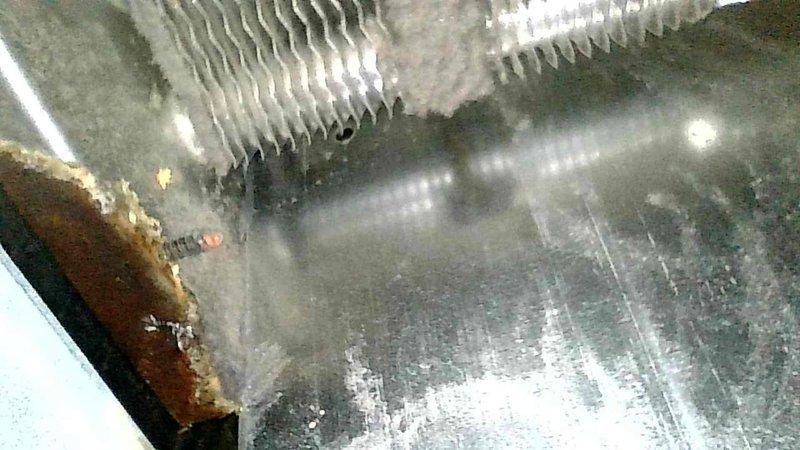 Responded to no-heat complaint on 10+ year old York LP modulating furnace. Detected aldehyde odor indicative of rotted secondary heat exchanger upon arrival. Inspection confirmed secondary heat exchanger failure with visible perforation, excessive black exhaust deposits, and water accumulation around unit. Visual inspection via camera showed customer the deteriorated component. Determined likely cause was previous gas valve malfunction leading to sooting, secondary heat exchanger plugging, and subsequent corrosion. Equipment was shut down and tagged out for safety due to carbon monoxide hazard. Customer declined repairs based on system's ongoing reliability issues.