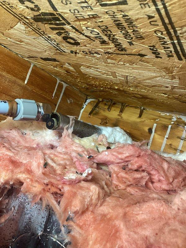 Responded to emergency water leak in basement caused by lawn faucet failure. Diagnostic inspection revealed the lawn faucet had completely separated from its connection point, with active water spraying from a damaged PVC pipe and metal connector. Removed damaged components, installed new lawn faucet assembly, and verified proper operation with no leaks. Water damage was contained primarily to the basement area with some moisture affecting floor joists and insulation.