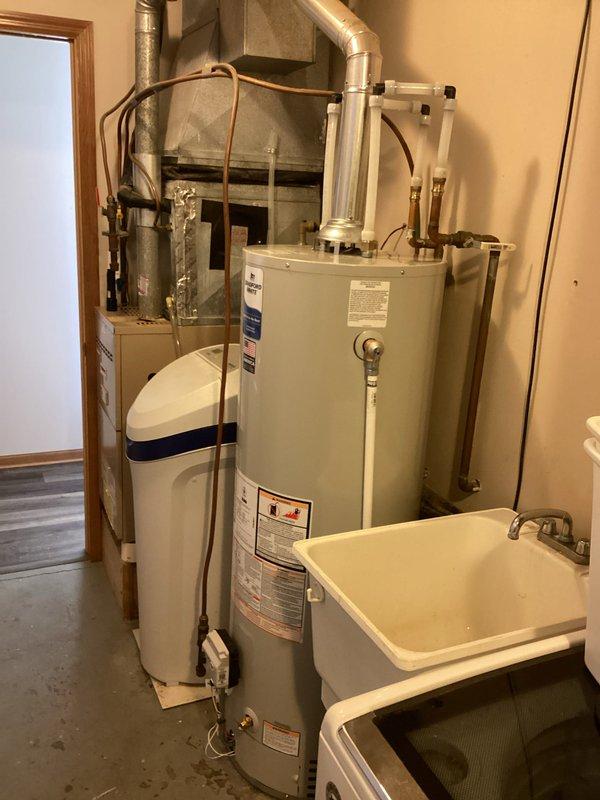 Successfully installed a 40-gallon standard vent natural gas water heater as sold by Kegan. The new unit was properly connected to existing copper pipes, PVC lines, and metal ductwork in the utility room, with all connections secured and tested for proper operation.