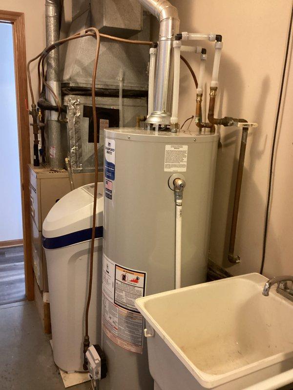 Successfully installed a 40-gallon standard vent natural gas water heater as sold by Kegan. The new unit was properly connected to existing copper pipes, PVC lines, and metal ductwork in the utility room, with all connections secured and tested for proper operation.