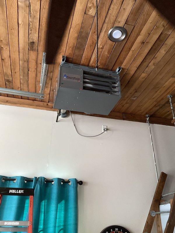 Diagnosed and serviced LP garage heater that was not operational. Found tripped rollout switch, performed heat exchanger inspection with no visible issues detected. Reset rollout switch, verified proper ignition and operation, then checked gas pressure readings (both incoming and manifold) which tested within acceptable parameters. Determined likely cause was regulator freeze during recent cold weather causing momentary flashback.