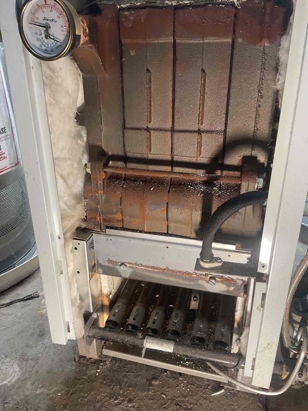 Responded to no heat call for natural gas furnace of indeterminate age. Inspection revealed broken ignition box and heat exchanger seal, creating potential for dangerous gas leakage. Additionally, observed significant corrosion throughout system, debris accumulation on burner tubes, and faulty transformer sending only 14V (insufficient for proper operation). Due to multiple critical safety issues and extensive deterioration, complete system replacement was performed rather than attempting repairs on the severely compromised unit.