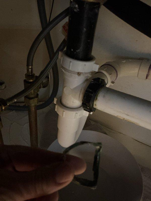 Addressed kitchen sink leak affecting basement. Removed garbage disposal and completely repiped under-sink drainage system with new strainers. Corrected improper uphill drain configuration and replaced faulty washer that were causing water to back up and leak through to basement.