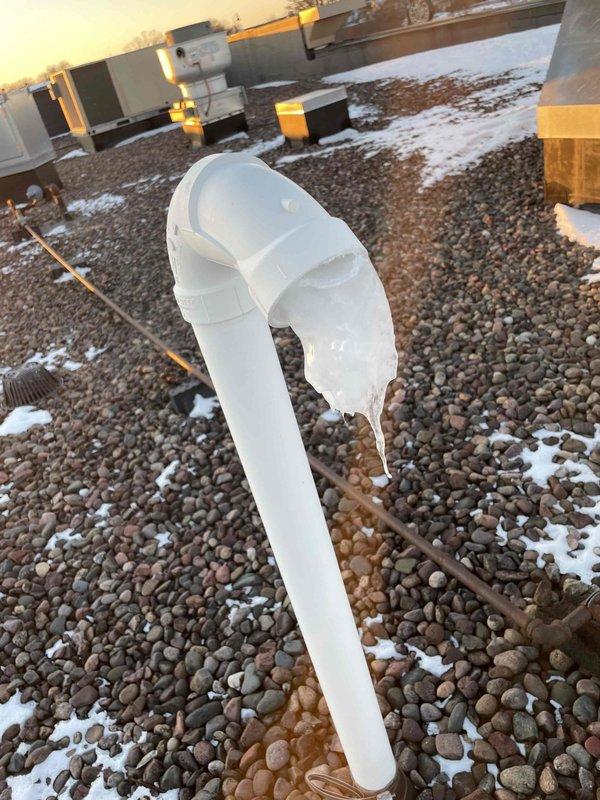 Responded to service call for Navien tankless water heater reporting error code 205. Diagnosed exhaust pipe on roof was frozen and blocked with ice formation at elbow joint. Cleared ice blockage from exhaust vent, restored proper ventilation, and verified system operation by testing multiple hot water cycles. Unit now functioning normally with proper exhaust flow.