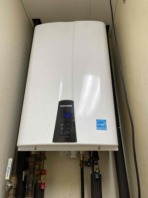 Responded to service call for Navien tankless water heater reporting error code 205. Diagnosed exhaust pipe on roof was frozen and blocked with ice formation at elbow joint. Cleared ice blockage from exhaust vent, restored proper ventilation, and verified system operation by testing multiple hot water cycles. Unit now functioning normally with proper exhaust flow.