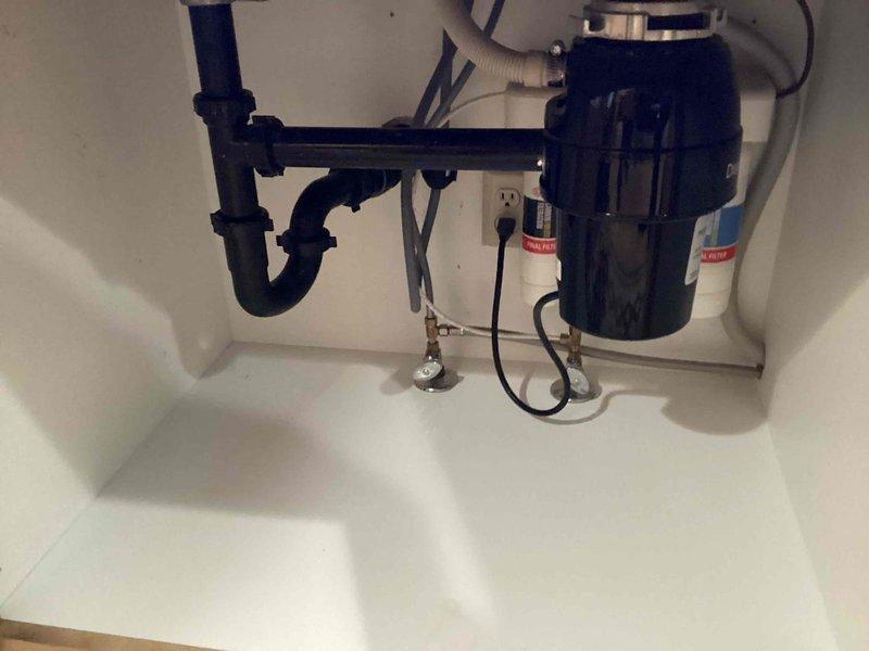 Responded to service call for clogged kitchen sink that was operating normally for a few minutes before drainage stopped. Diagnosed slow drainage issue; inspected garbage disposal unit and PVC drain assembly including P-trap. System was cleared and proper drainage function restored.