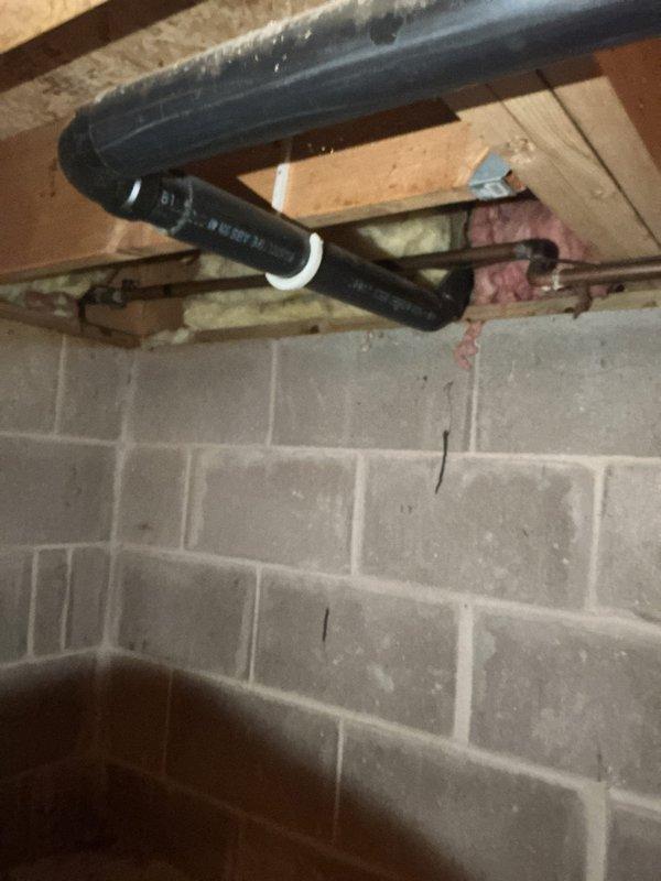 Responded to service call for slow-draining kitchen sink. Identified frozen drain line in crawl space due to inadequate insulation on exterior wall, which was causing the blockage. Cleared the frozen section and restored proper drainage. Inspected upstairs bathroom toilet and provided replacement recommendation based on observed tank corrosion and aging internal components.