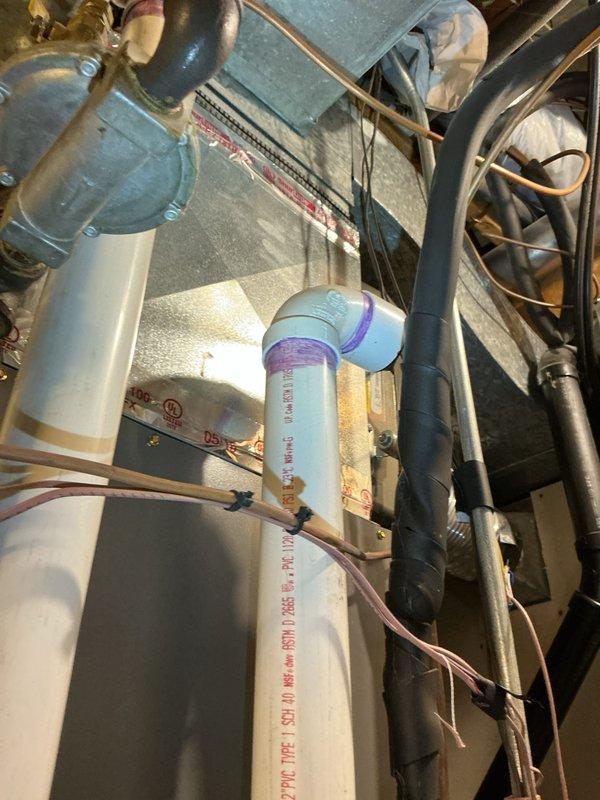Performed scheduled tune-up on HVAC system, identifying condensate drain issue causing water leakage. Secured loose condensate tube connection, cleaned condensate trap per manufacturer warning label, and thoroughly dried affected area. System now functioning properly with no further leakage observed.