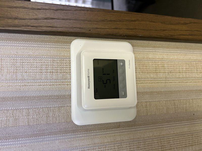Diagnosed no heat complaint in commercial property's front office. Found one of two LP furnaces non-operational due to failed thermostat with battery corrosion damage. Replaced damaged thermostat, cleaned connections, and verified proper system operation. Second furnace was functioning normally throughout service call.