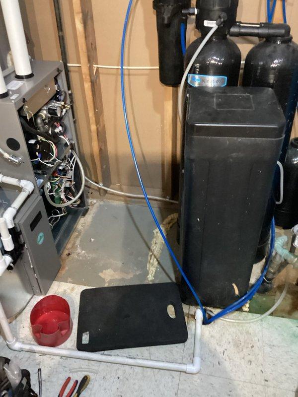 Diagnosed persistent no-heat issue occurring after previous service visits. Found condensate accumulation in combustion blower preventing unit startup. Drained water from blower assembly and implemented permanent solution by drilling drainage hole through furnace deck, installing a trap, and running a hose directly to drain to prevent future water accumulation in the combustion blower.