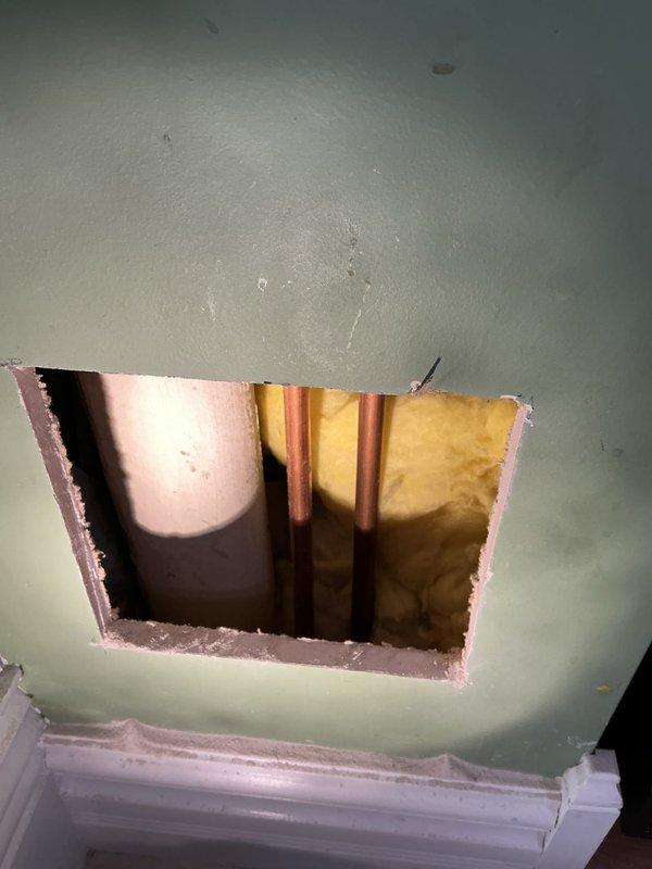 Responded to a service call for a frozen and split copper water line that supplies the upstairs bathroom and laundry. Created an 8x8 access hole to reach the damaged pipe, which had previously been improperly repaired with a wrap. Successfully replaced the broken section of copper pipe, restoring water flow to the upper level. Customer was informed that drywall repair services are not included.