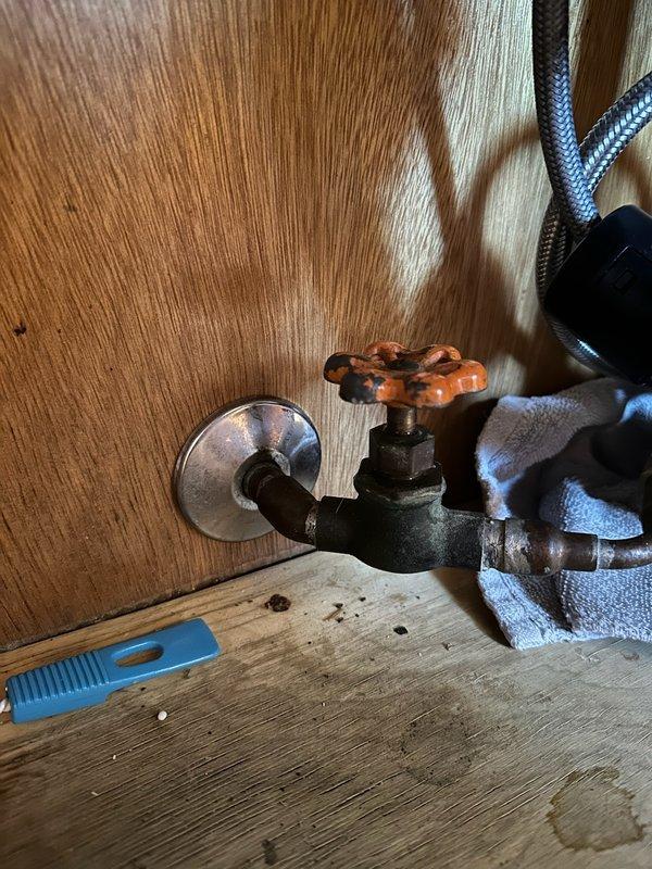 Replaced seized and leaking gate valve under kitchen sink that was feeding dishwasher. Removed old corroded valve and installed new angle stop valve on water supply line, which required cutting access in the cabinet. Corrected water leak and restored proper functionality to dishwasher water supply.