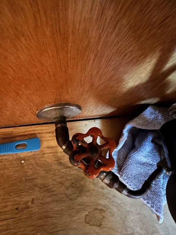 Replaced seized and leaking gate valve under kitchen sink that was feeding dishwasher. Removed old corroded valve and installed new angle stop valve on water supply line, which required cutting access in the cabinet. Corrected water leak and restored proper functionality to dishwasher water supply.
