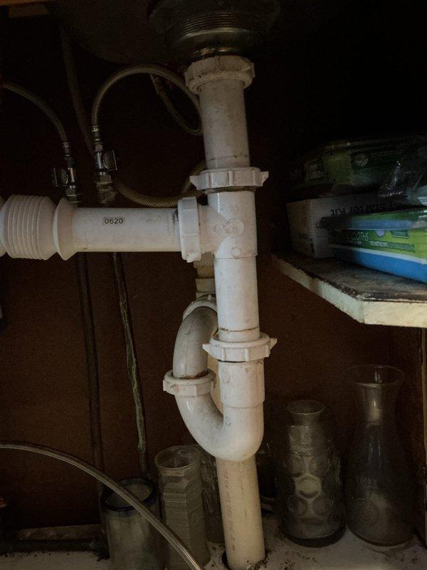 Responded to water leak call where customer experienced water intrusion into basement after frozen pipe thawed. Diagnosed issue as broken dishwasher valve due to freezing and improperly connected drain line. Shut off water supply to dishwasher, advised customer to contact appliance repair service, and reconstructed P-trap assembly under kitchen sink with proper connections to resolve drainage issue.