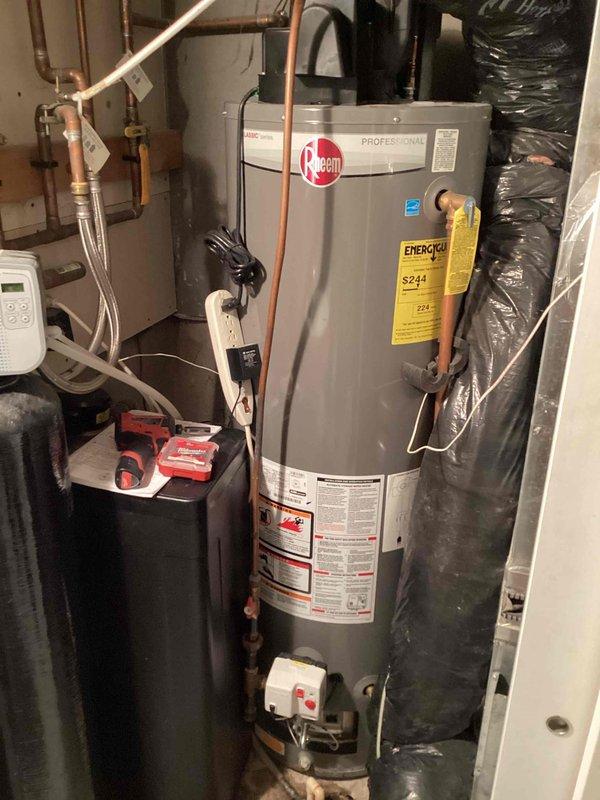 Responded to service call for Rheem Professional water heater not igniting. Upon inspection, discovered water leaking onto burner assembly, preventing proper pilot light operation. Diagnosed as tank leak requiring replacement. Provided customer with replacement estimate and explained options.