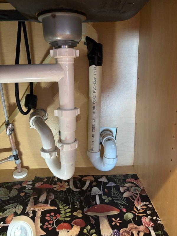 Responded to customer complaint of sewage odor in kitchen drain. Diagnosed improper dishwasher drain installation with no high loop and excessive insertion into standpipe. Corrected by installing proper high loop and reducing insertion depth to 5-6 inches, eliminating sewer gas backflow risk.