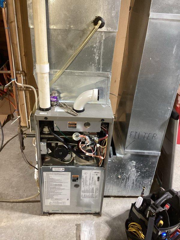 Responded to no-heat call for 8-12 NG furnace (6 years old). Diagnosed system shutdown due to open low pressure switches. Inspected venting and condensate lines, finding one pressure switch line plugged. Cleared obstructed pressure switch line using nitrogen. Performed preventive maintenance including heat exchanger inspection and flame sensor cleaning. System restored to proper operation after service. Recommended customer obtain estimates for collector box and burner replacement.