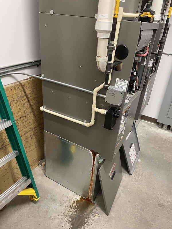 Inspected five HVAC units across the facility. Found two twinned furnaces for community room with frozen exhaust pipes on roof. Diagnosed garage hanging heater with blown 5 amp fuse and shorted control board requiring replacement. Resolved heating distribution issues in office areas by correcting thermostat settings from AC to heat mode and adjusted boiler control parameters. Identified additional maintenance needs including failing blower motor in Furnace 4 and leaking exhaust pipe connections on Furnace 3.