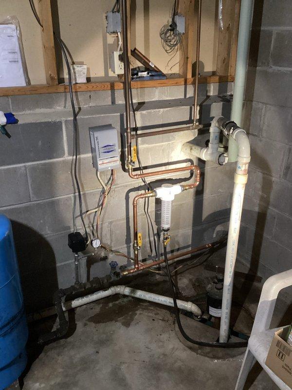 Installed a Rusco Spin Down Whole House Sediment 1" Inline Filter to improve water quality and protect plumbing fixtures from mineral damage. Removed old gate valve and completed all necessary pipe connections. Tested hot water lines and identified potential recirculation pump issue, as no vibration was detected when pump was plugged in, with temperature differential of approximately 10 degrees observed when recirculation line was closed.