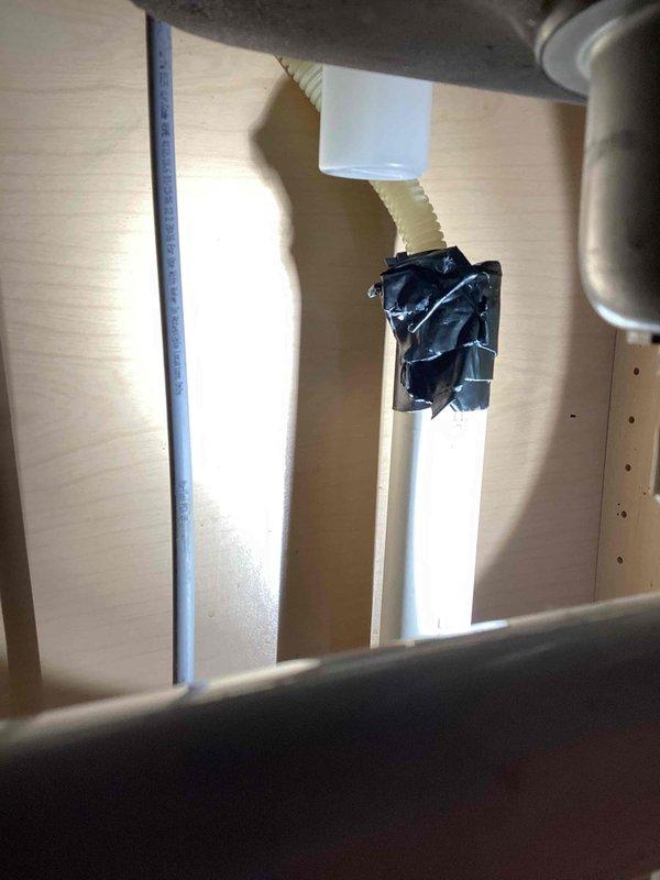 Responded to service call regarding dishwasher drainage issues. Inspection revealed 20+ year old unit with failing drain pump. Checked plumbing connections including PVC drain lines and air core ventilation pipes; all connections secure with temporary tape seals observed at pipe junctions. Advised customer that replacement of dishwasher unit is recommended rather than repair due to age of appliance.