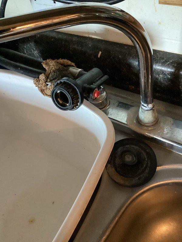 Installed customer-supplied water heater in mobile home, converting from electric to gas system. Observed significant mineral/sediment buildup around kitchen faucet and provided estimate for replacement, which customer declined.