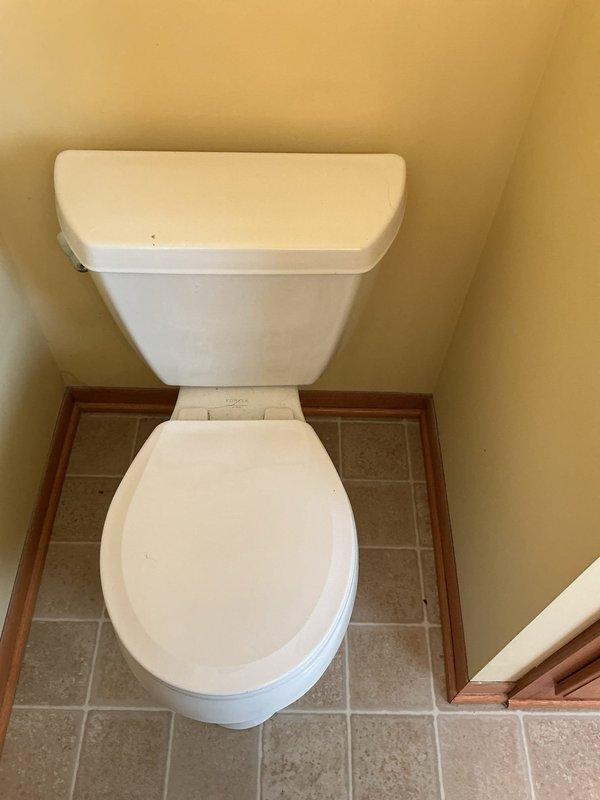 Responded to service call for toilet leakage causing water damage to living room ceiling. Diagnosed a defective wax ring and overflow situation from upstairs bathroom. Removed toilet, replaced wax ring and angle stop valve, then reinstalled and tested toilet to ensure proper function and no further leakage.