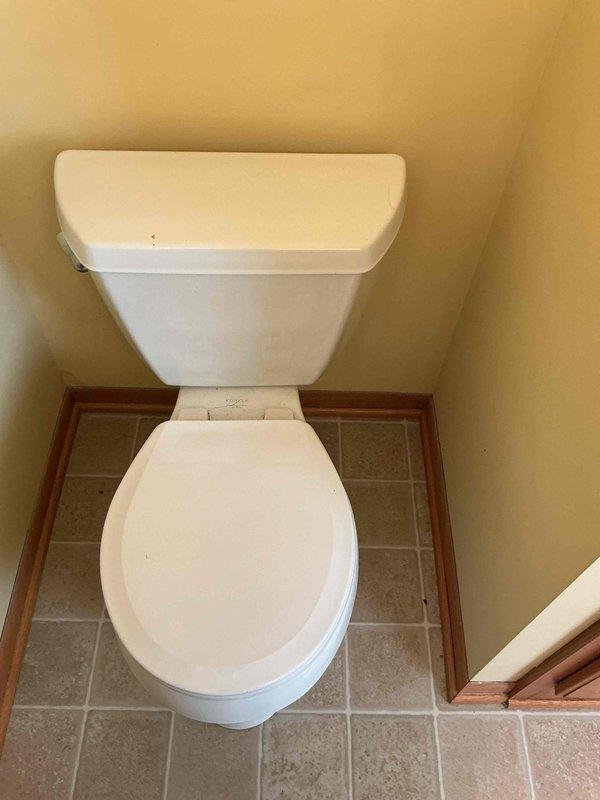 Responded to service call for toilet leakage causing water damage to living room ceiling. Diagnosed a defective wax ring and overflow situation from upstairs bathroom. Removed toilet, replaced wax ring and angle stop valve, then reinstalled and tested toilet to ensure proper function and no further leakage.