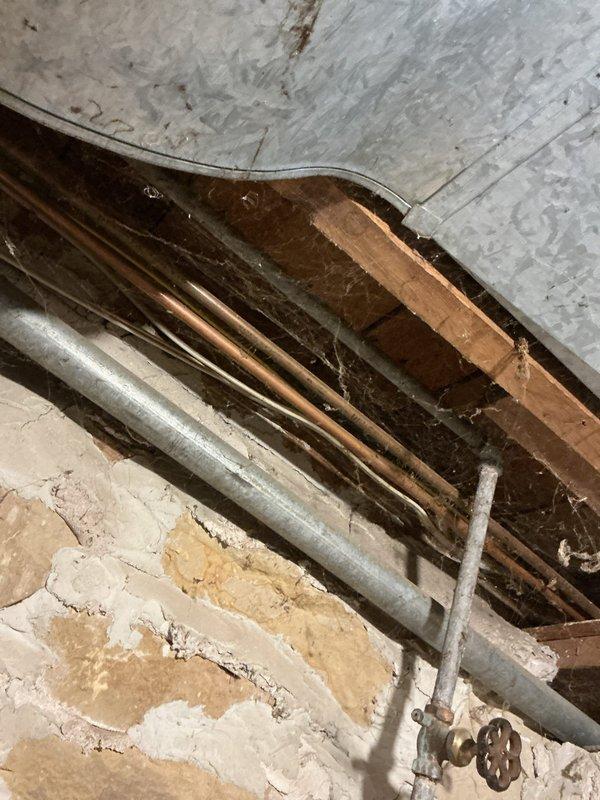 Responded to service call for water leak in basement. Identified source as a disconnected hot water line previously feeding to kitchen sink. Noted significantly reduced pressure in kitchen sink cold water line. Recommended complete re-piping of water lines to kitchen to resolve both the active leak and pressure issues. Inspected crawl space access and HVAC system during service visit.