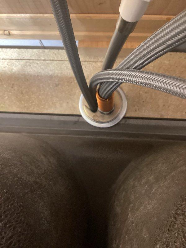 Responded to service call regarding loose kitchen faucet. Diagnosed issue as oversized hole in mounting surface causing instability. Installed large washer to secure faucet properly and provide additional support. Faucet now properly stabilized.