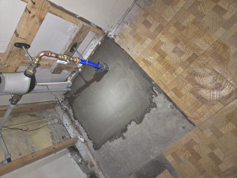 Completed concrete fill work around newly installed water supply line. Addressed previously excavated area where new copper supply pipe with brass fittings was installed. Successfully backfilled and finished concrete surface to properly seal opening while maintaining accessibility to plumbing components.