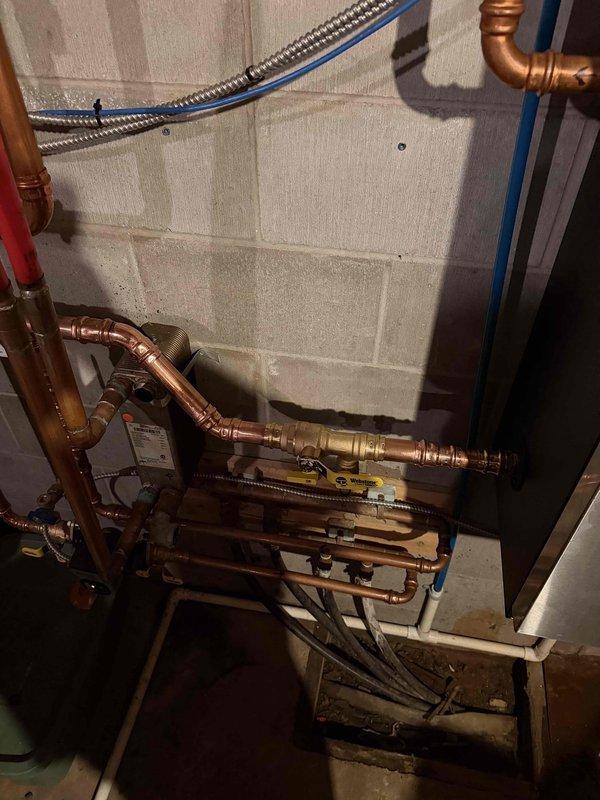 Repaired heating system by bypassing clogged plate heat exchanger, directly repiping boiler connections with copper piping. Replaced fill valve and performed complete system bleed to restore proper circulation and heating efficiency.