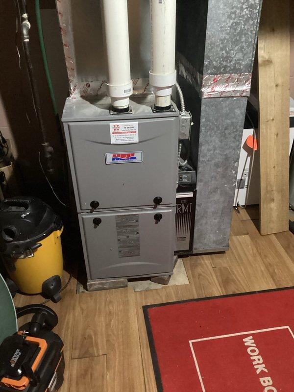 Resolved intermittent heating issue on Heil furnace by cleaning water from pressure switch port and inducer drain. Verified gas pressures and checked system operation to address reported sporadic heating performance and gas odor from exterior exhaust pipe.