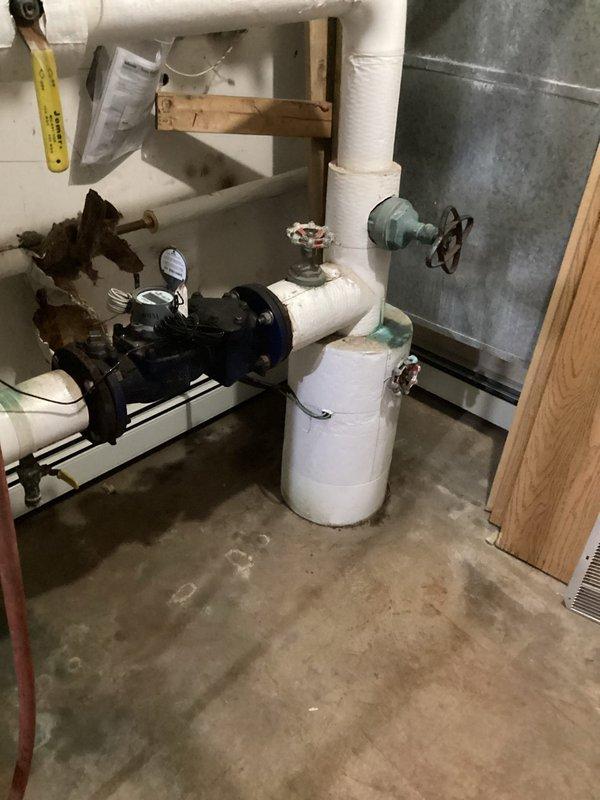 Successfully replaced damaged fintube section in basement utility room and repaired associated baseboard. System now has proper flow through the blue valve assembly with all PVC connections secure and properly insulated.