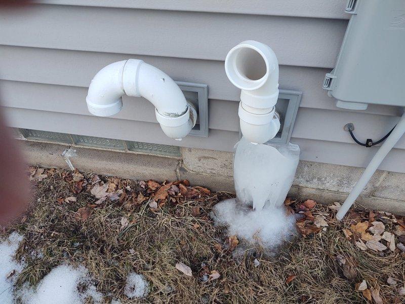 Repaired cracked PVC exhaust pipe by installing a Fernco connector and new piping. Ice buildup was observed at the base of the exterior pipe. Customer was informed that a permanent glue fitting could be installed in warmer weather if needed, but approved the current repair solution.