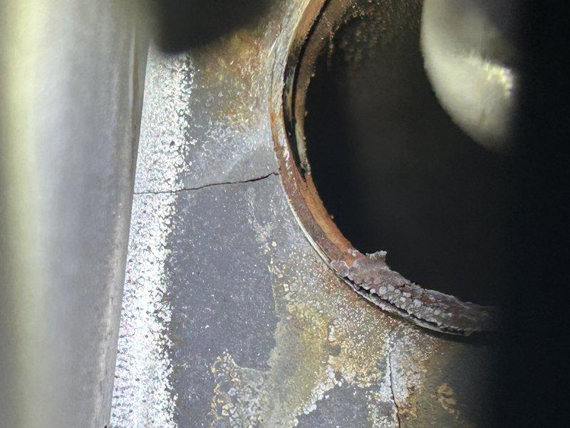Responded to no heat call on LP furnace. Upon inspection, discovered seized inducer motor and multiple cracks in the heat exchanger faceplate. Visual inspection confirmed significant corrosion and metal deterioration at critical connection points. Recommended replacement of system due to age (28 years) and safety concerns from compromised heat exchanger. Scheduled service advisor follow-up to discuss replacement options.