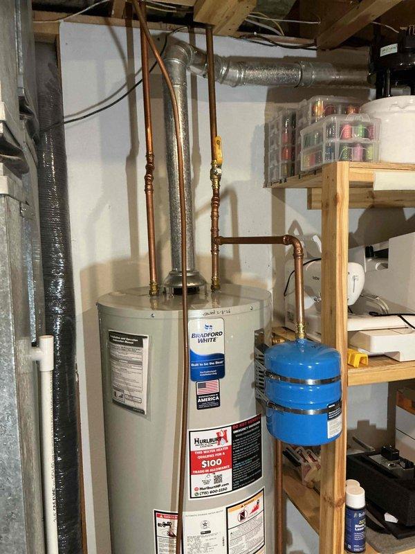 Replaced leaking Bradford White water heater with a new model of similar capacity due to tank failure detected at the bottom of the unit. Installation included proper connection of copper supply lines and installation of expansion tank to meet code requirements.