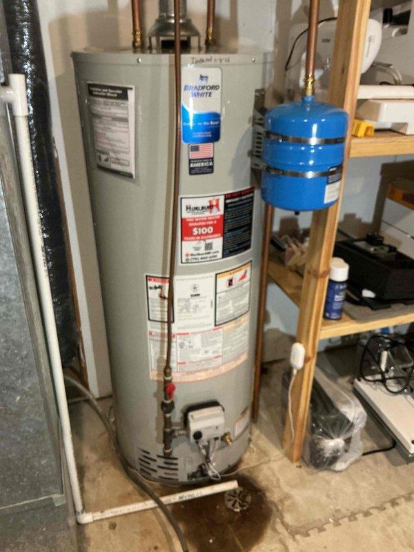 Replaced leaking Bradford White water heater with a new model of similar capacity due to tank failure detected at the bottom of the unit. Installation included proper connection of copper supply lines and installation of expansion tank to meet code requirements.