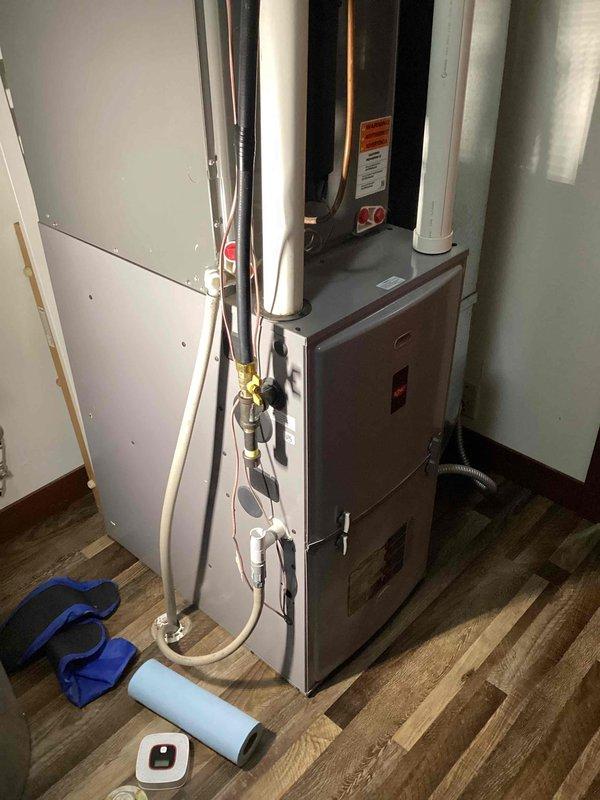 Repaired gas leak at furnace by removing and reinstalling nipple fitting with proper pipe dope and tightening. Installed in-line drain on intake to address customer's concerns about condensation backflow, with drain line routed to floor drain. Performed leak test throughout utility room with no additional leaks detected.
