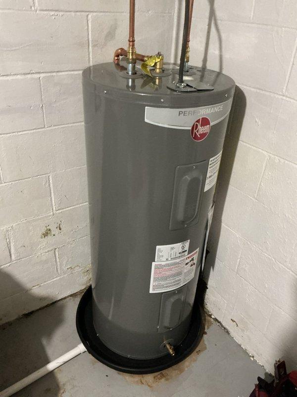 Replaced customer-supplied 40-gallon electric Rheem Performance water heater due to rust damage on the bottom of the original unit. New installation completed with all necessary plumbing connections and properly positioned on a drain pan in the utility area.