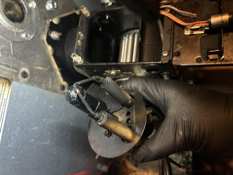 Responded to no-heat complaint on oil furnace that was in lockout condition. Upon inspection, found nozzle heavily clogged and approximately 1" of standing water in work area. Performed maintenance including nozzle replacement and filter replacement, noting non-standard filter assembly configuration. After initial service, unit continued to exhibit same symptoms. Tested CAD cell with no improvement. Diagnosed need for primary control replacement; parts ordered for follow-up service.