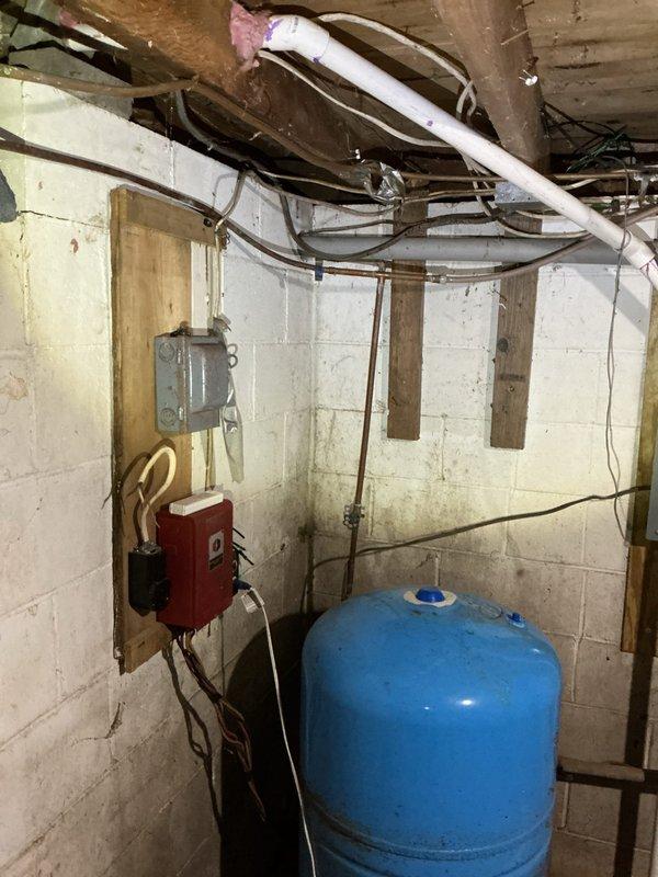 Conducted a follow-up inspection of basement plumbing system for insurance adjuster evaluation. Assessed aged copper piping network and pressure tank showing signs of water damage on surrounding concrete block walls. Documented condition of utility area infrastructure to prepare comprehensive replacement estimate as requested by customer.