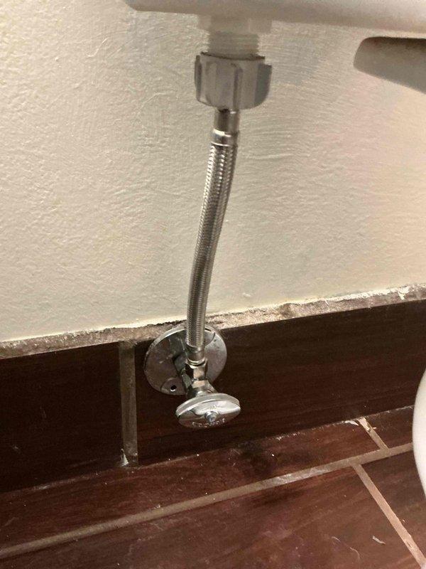 Diagnosed and repaired water leakage from toilet by replacing faulty supply line and angle stop valve. Previous service had addressed a wax ring issue, but new leak was identified at the supply connection and valve packing. Installed new braided stainless steel supply line and shut-off valve to resolve the issue.