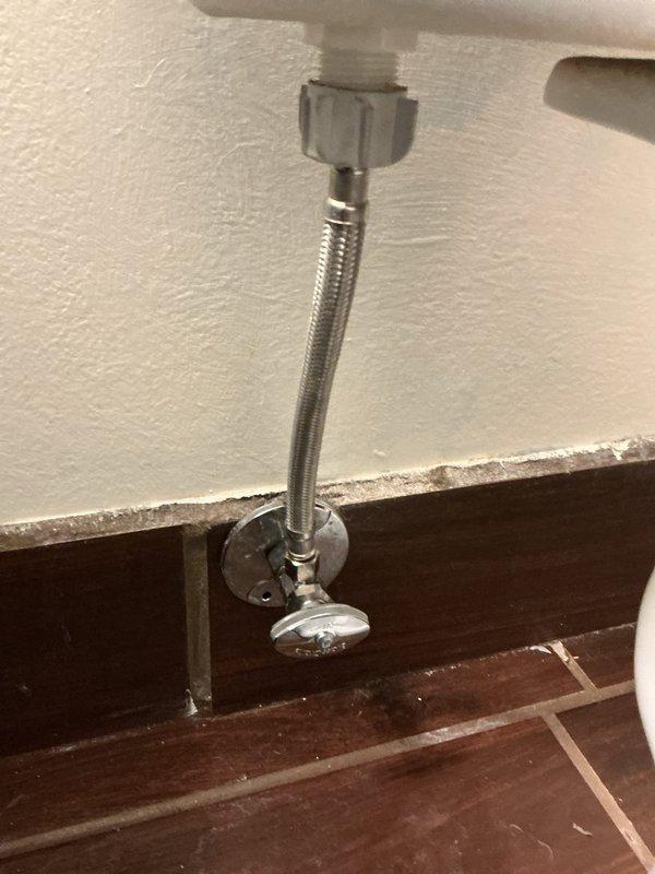 Diagnosed and repaired water leakage from toilet by replacing faulty supply line and angle stop valve. Previous service had addressed a wax ring issue, but new leak was identified at the supply connection and valve packing. Installed new braided stainless steel supply line and shut-off valve to resolve the issue.